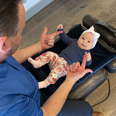 Dr Matt Savona examining a smiling infant in Dublin PA